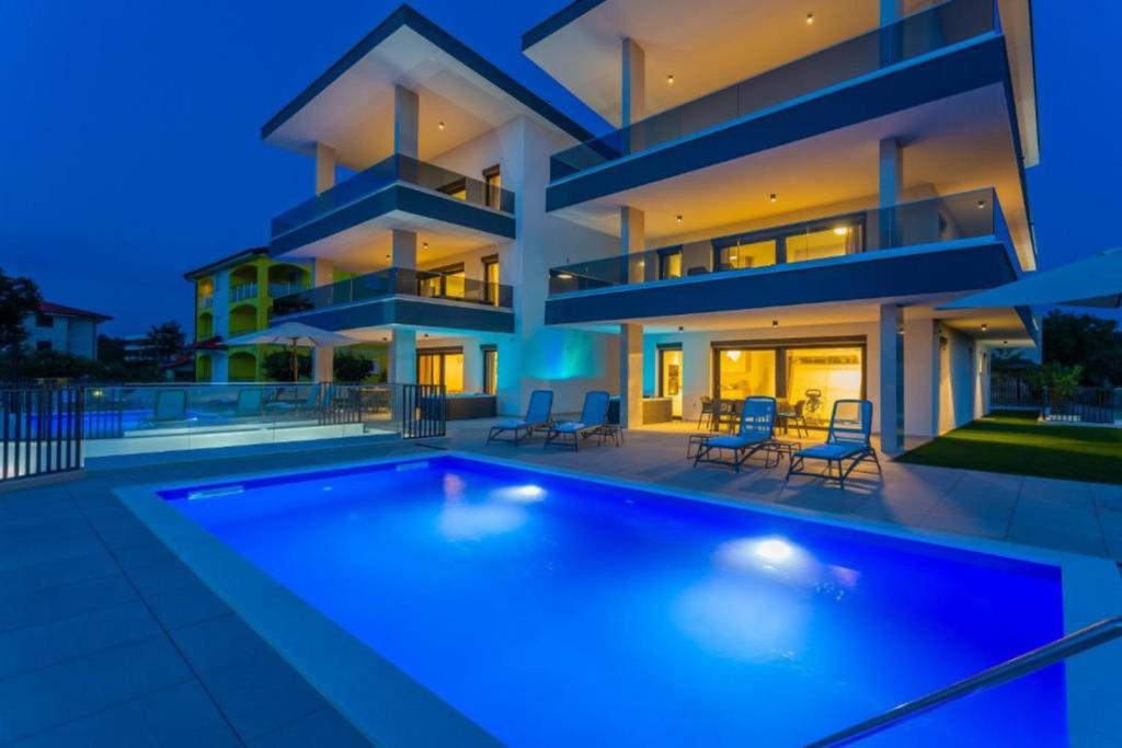 a large house with a swimming pool in front of it at Penthouse Apartment Maya with Pool and Jacuzzi in Sveti Anton