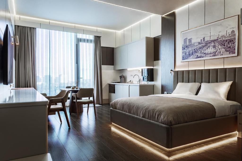 a hotel room with a bed and a kitchen at Central one new apartments - panoramic skyline & boulevard in Tashkent
