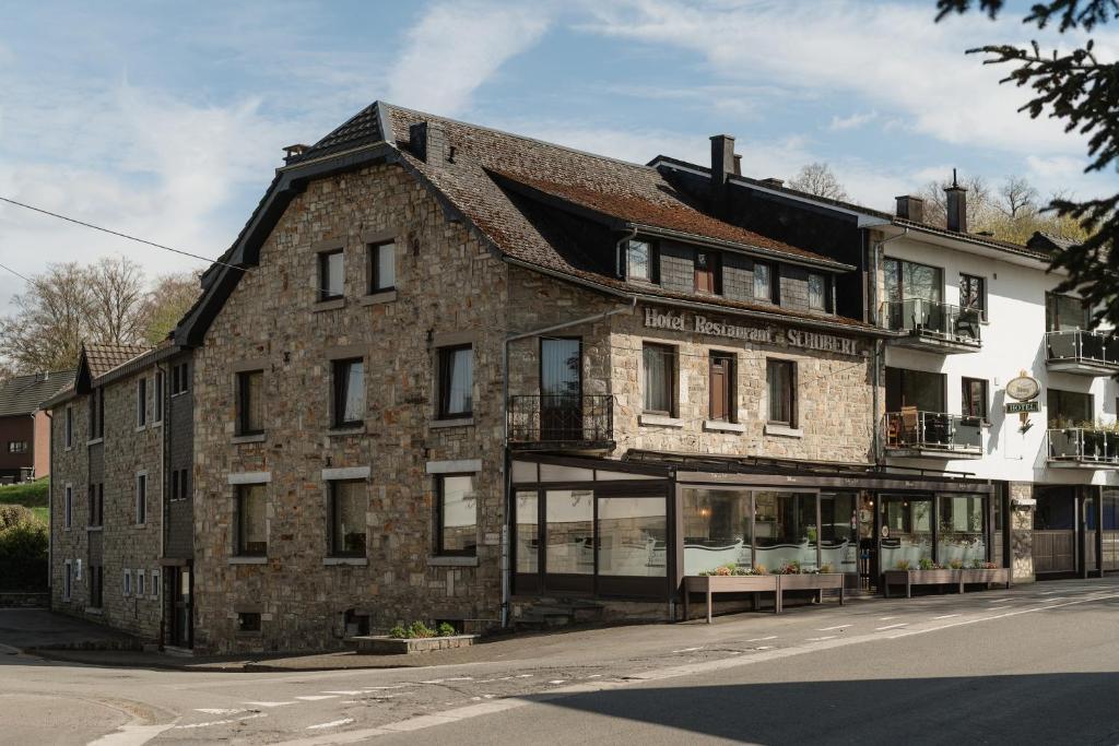 ein altes Backsteingebäude an der Ecke einer Straße in der Unterkunft Hotel Saint-Hubert in Malmedy