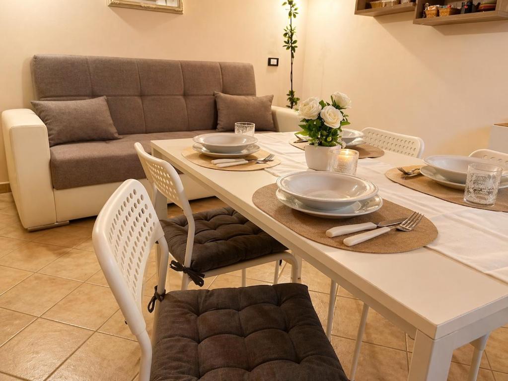 a dining table with plates and dishes on it with a couch at Apartment between Pisa Lucca and Florence in Cascina