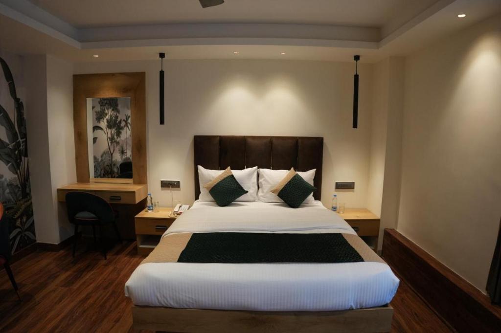 a bedroom with a large bed and two tables and a desk at Trevon Twin Tree Inn in Dhanbād