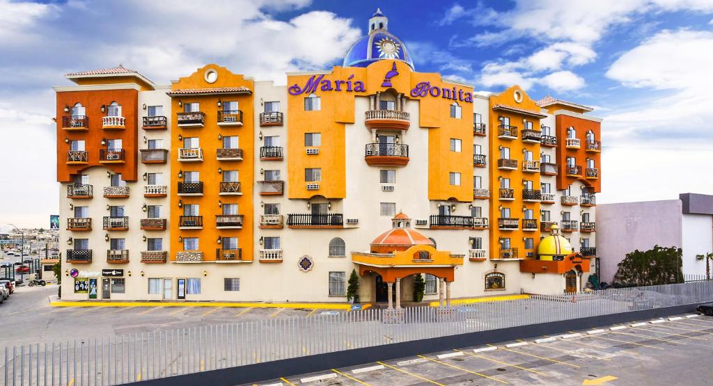un gran edificio blanco y amarillo con un cartel. en Hotel María Bonita Consulado Americano, en Ciudad Juárez