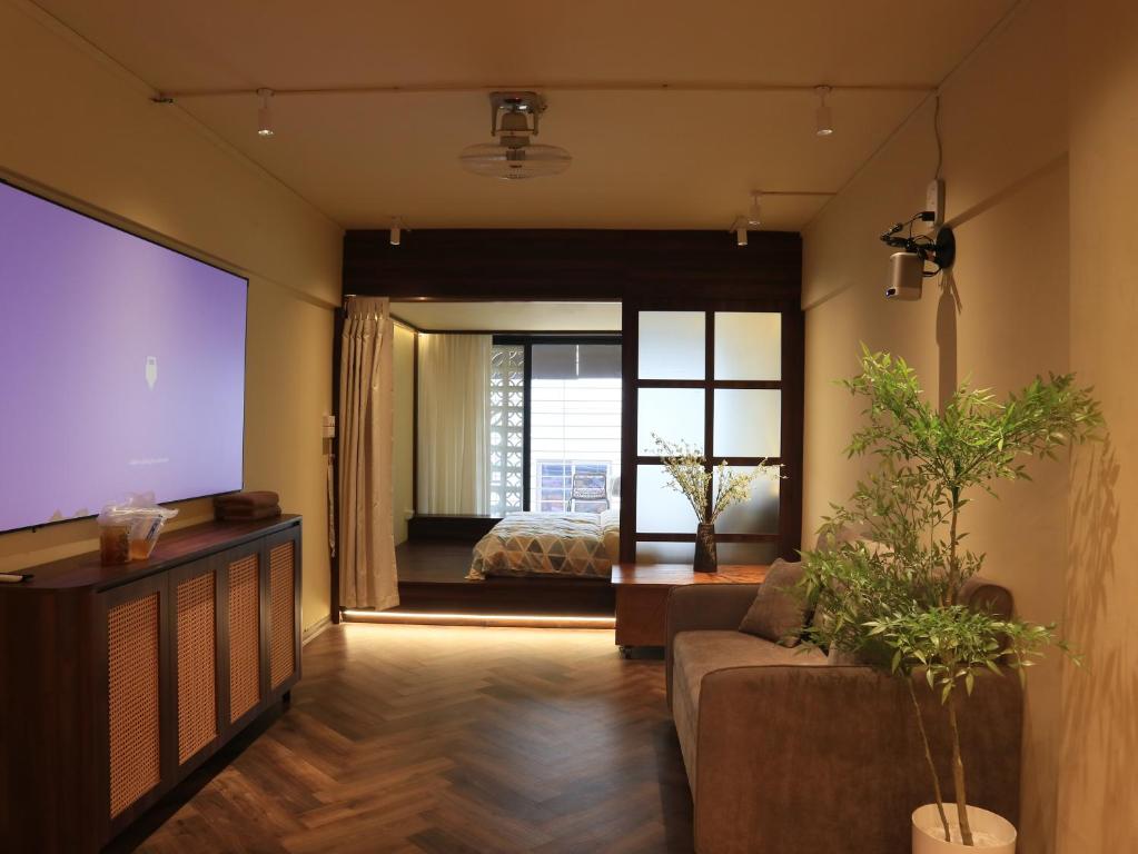 a living room with a couch and a bedroom at Smile Home in Hanoi