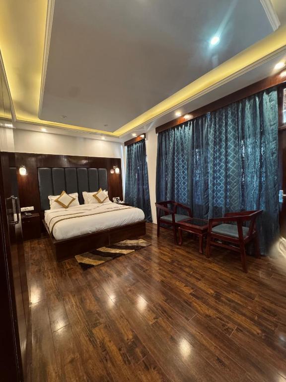a bedroom with a bed and a large window at The Grand K2 Hotel in Leh