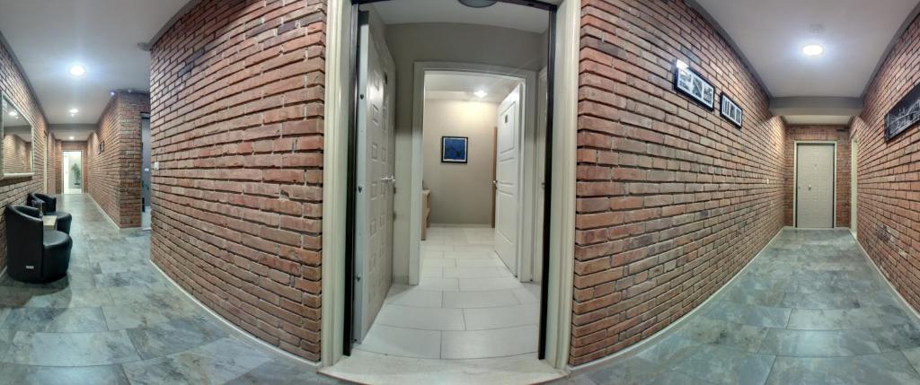 a hallway in a building with a brick wall at Hotel Oresti Center in Tirana
