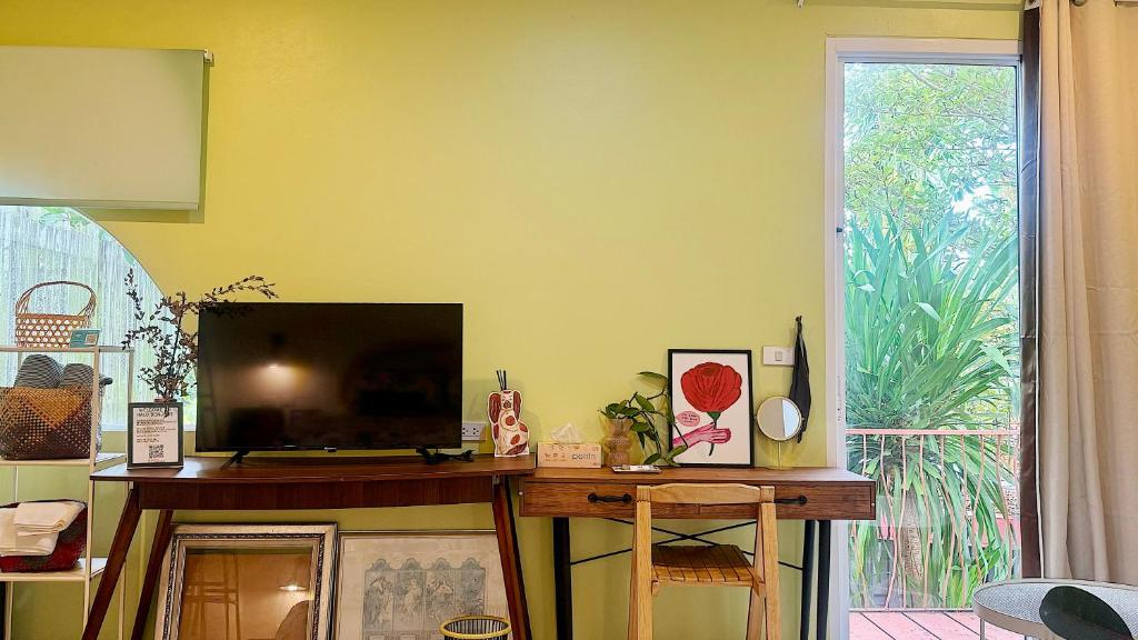 a living room with a flat screen tv on a table at Halo Bonjour Perch in Ban Chuang