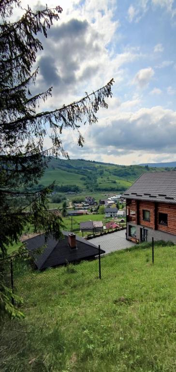 a house with a view of a field and a building at Loft Bucovina in Gura Humorului