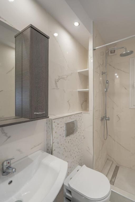 a bathroom with a toilet and a shower and a sink at Comfy Apt next to metro in Athens
