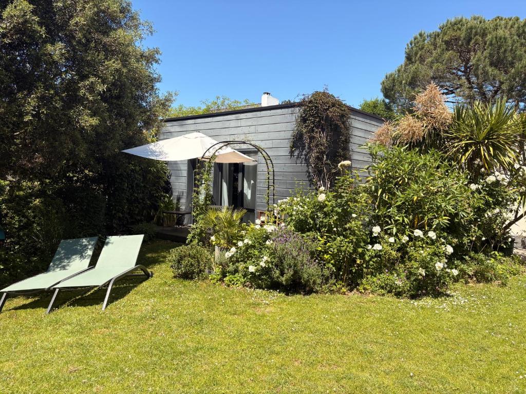 a white chair and an umbrella in a garden at Ker Mouettes in Arradon