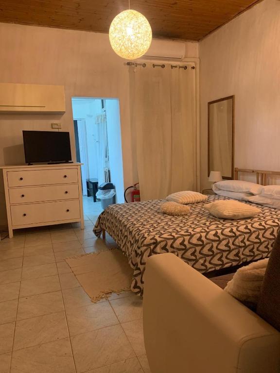 a bedroom with two beds and a tv and a couch at oasi di Villa Erbosa in Bologna