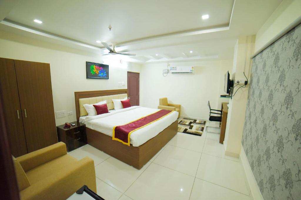 a bedroom with a bed and a couch and a television at The EMBASSY HOTEL in Guntūr
