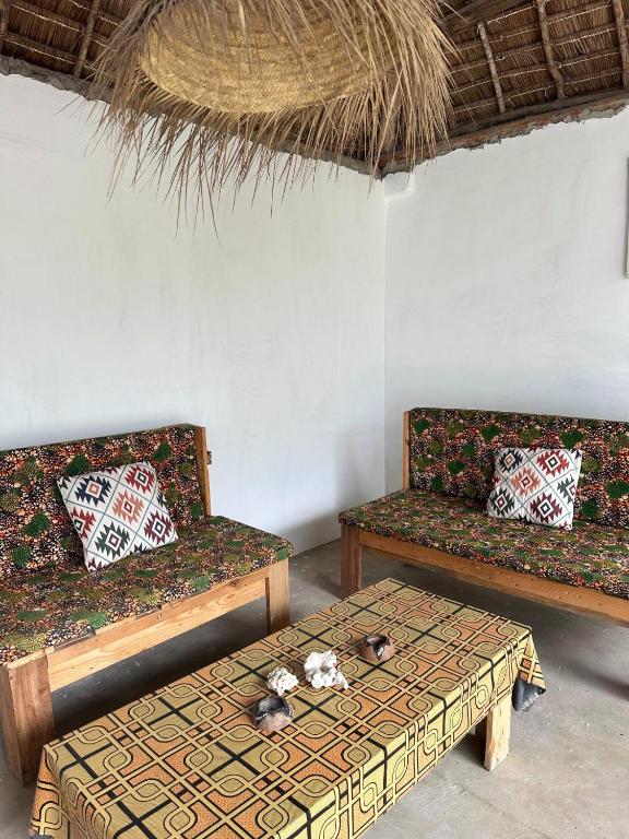 a living room with two couches and a table at Kipe House Nungwi in Nungwi