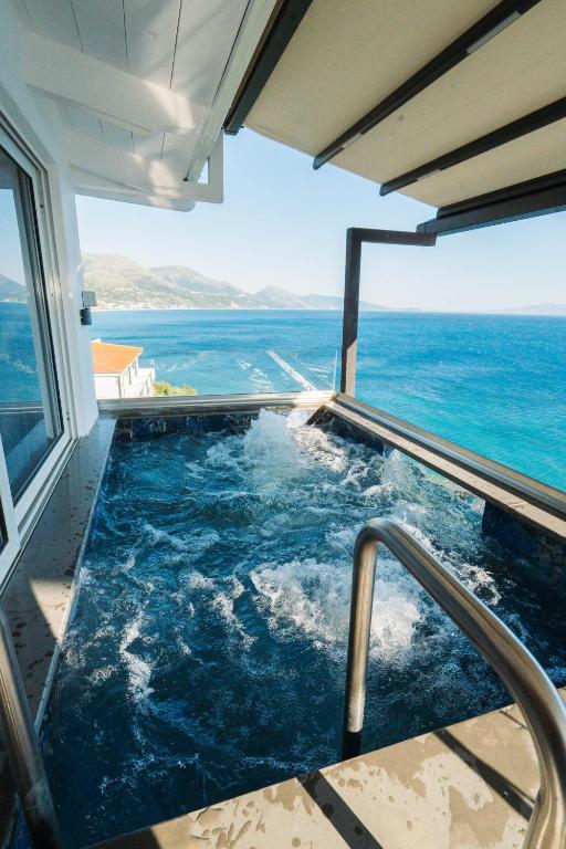 a swimming pool with a view of the ocean at Qeparo Napolon Complex in Qeparo