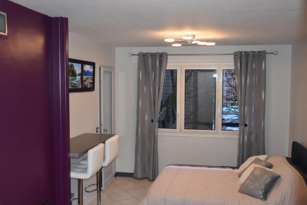 - une chambre avec un lit, un bureau et une fenêtre dans l'établissement La Forclaz, à Annecy