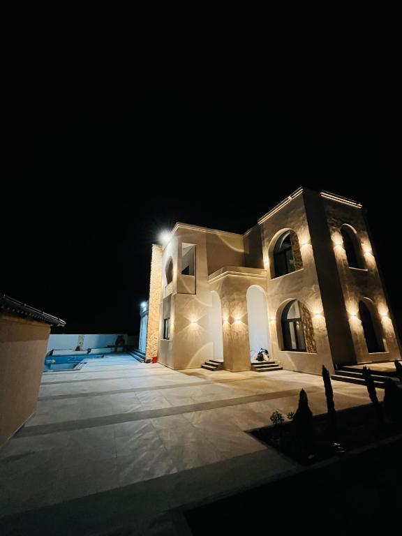 a large building with lights on it at night at ڤيلا الكرم in Jerash