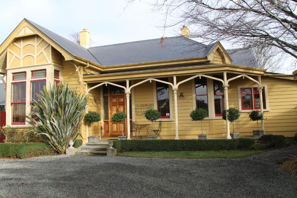 a yellow house with a porch at Villa Rouge B&B in Invercargill