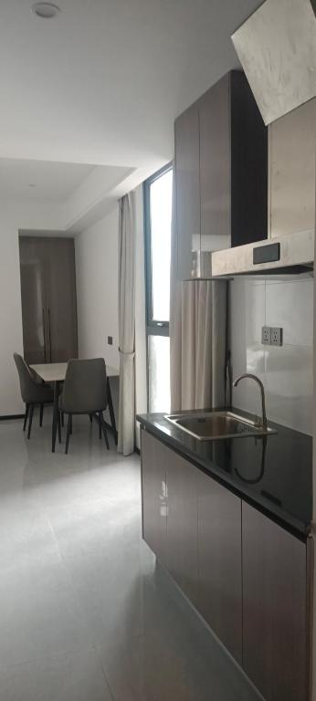 a kitchen with a sink and a table with chairs at CondoApsara in Phnom Penh