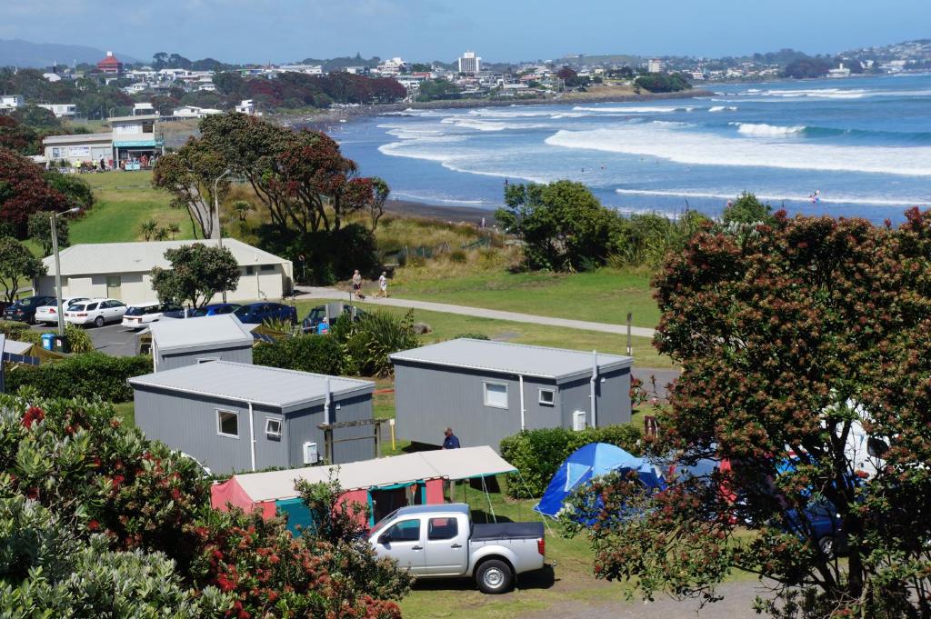 a view of a beach with houses and a truck at Fitzroy Beach Holiday Park in New Plymouth