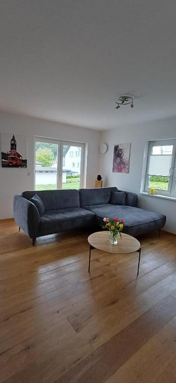 a living room with a blue couch and a table at Top Ferienwohnung Herborn in Herborn