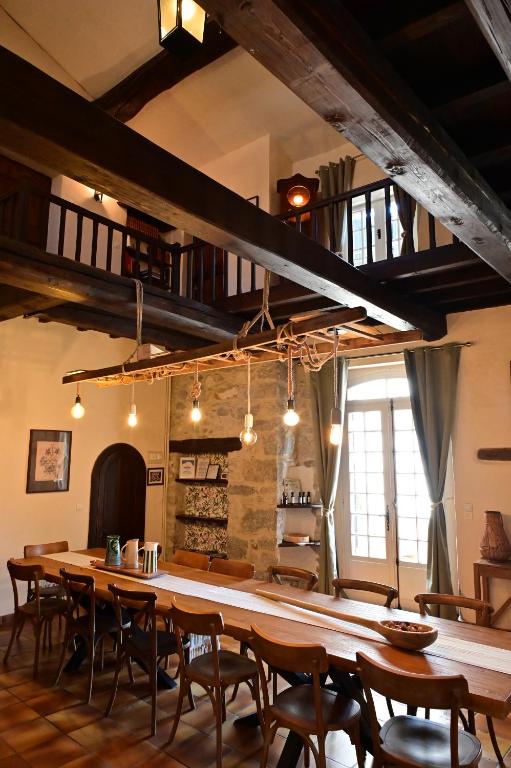 a dining room with a large wooden table and chairs at L'Oustal des Rameaux in Brissac