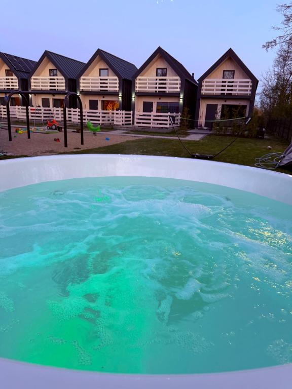 a pool of water in front of some houses at Ross-domki LUX Hause & Jacuzzi in Sarbinowo