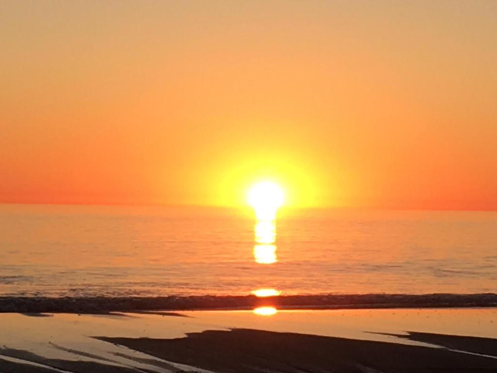 - un coucher de soleil sur la plage et un coucher de soleil sur l'océan dans l'établissement Adelaide - Semaphore Beach Front, à Adélaïde