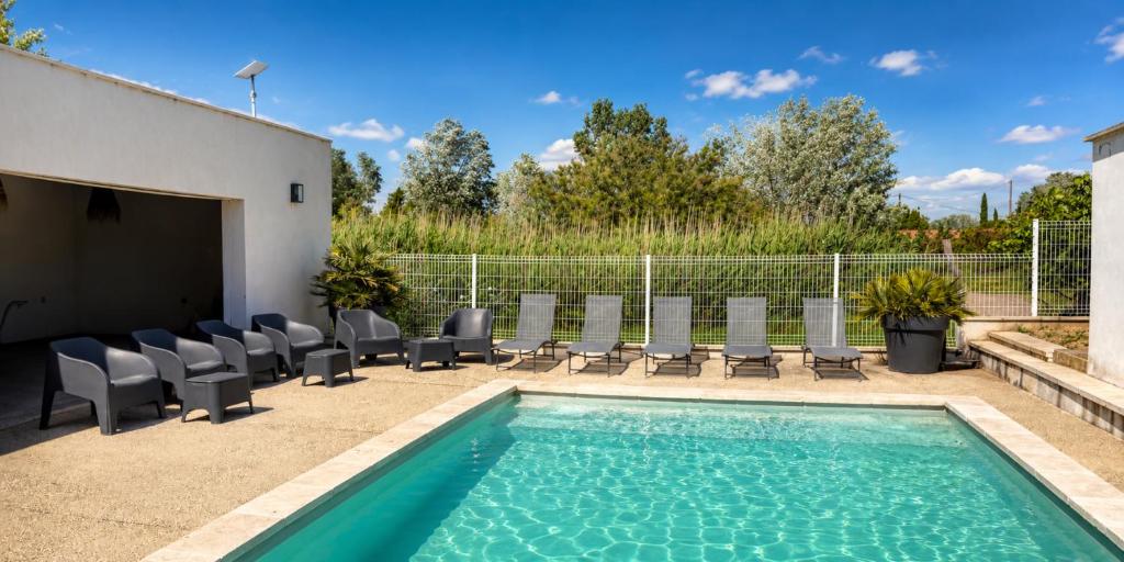 a swimming pool with lounge chairs and a swimming pool at LES MAISONS DU PATY in Arles