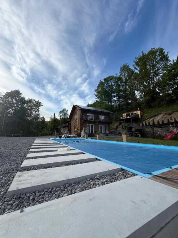 a swimming pool in front of a house at Dva Braty eco in Podobovets