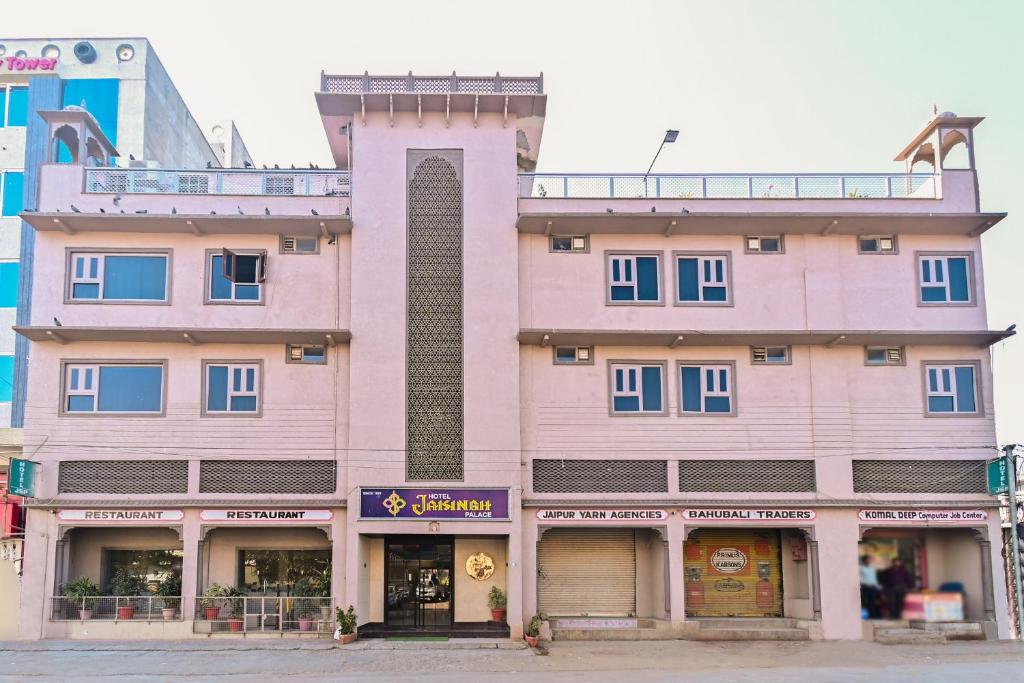 a pink building on a city street at Hotel Jaisingh Palace in Jaipur