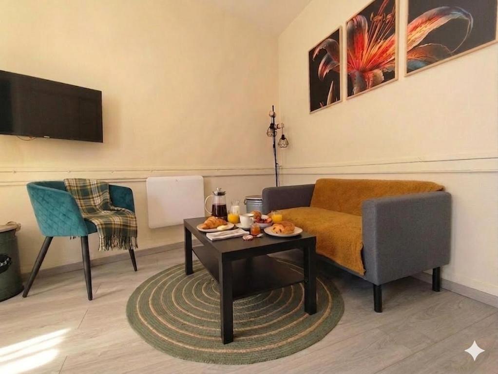 a living room with a couch and a table at Authentique Maison de Pêcheur Le Refuge in Le Tréport
