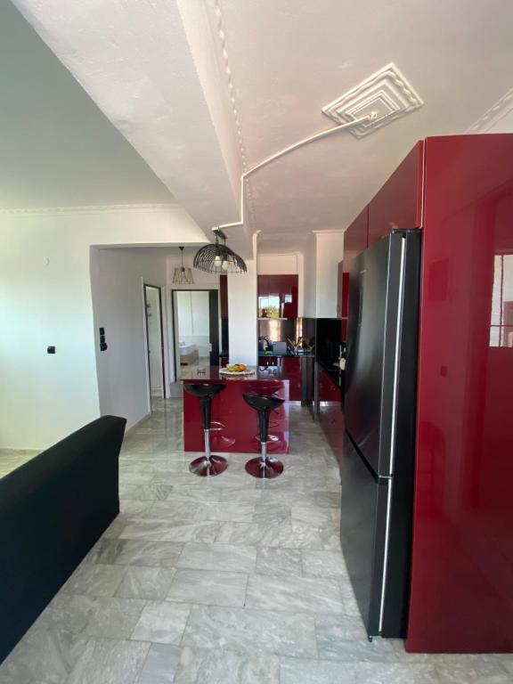 a kitchen with red cabinets and a black refrigerator at Selinia Apartments in Selínia