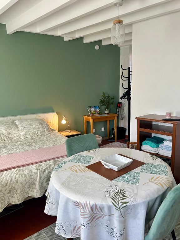 a bedroom with a bed with a table in it at La Maisonnette in Cellettes
