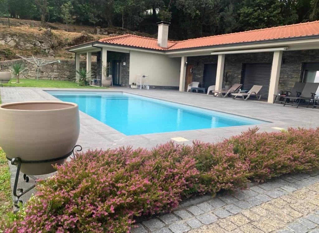 a swimming pool in front of a house at Casa do Alambique in Alvaredo