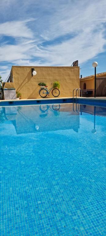 a swimming pool with a bike on the side of a building at Casa Rural Villa Arcadia in Corvera