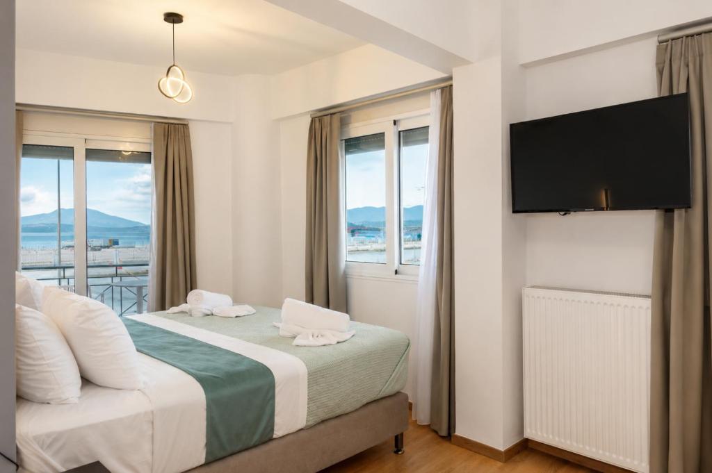 a bedroom with a bed with a flat screen tv at Pelagos Suites in Igoumenitsa