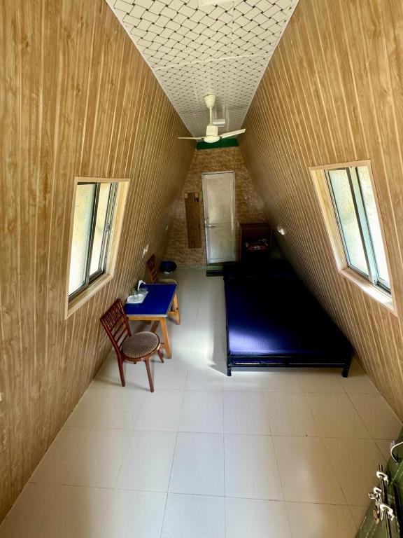 a room with a table and a blue table and two windows at Nalari Resort in Borpāni