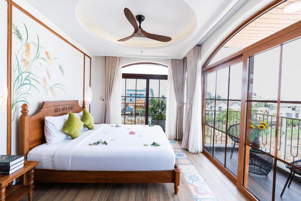 a bedroom with a bed and a balcony at Lúa Boutique Hoi An Hotel in Tân Thành (1)