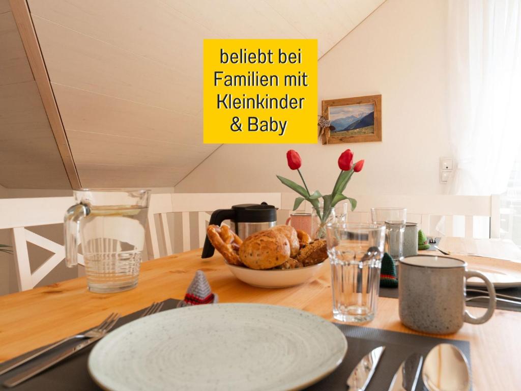 a table with a plate of food on top of it at Ferienwohnung Anemone - 4 Zimmer mit Bergblick & Alpenflair in Germaringen