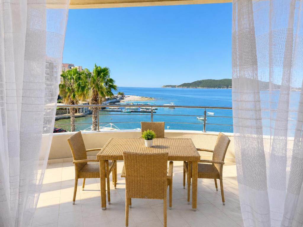 a table and chairs on a balcony with a view of the ocean at SPLENDID Sunset Penthouse in Rafailovici