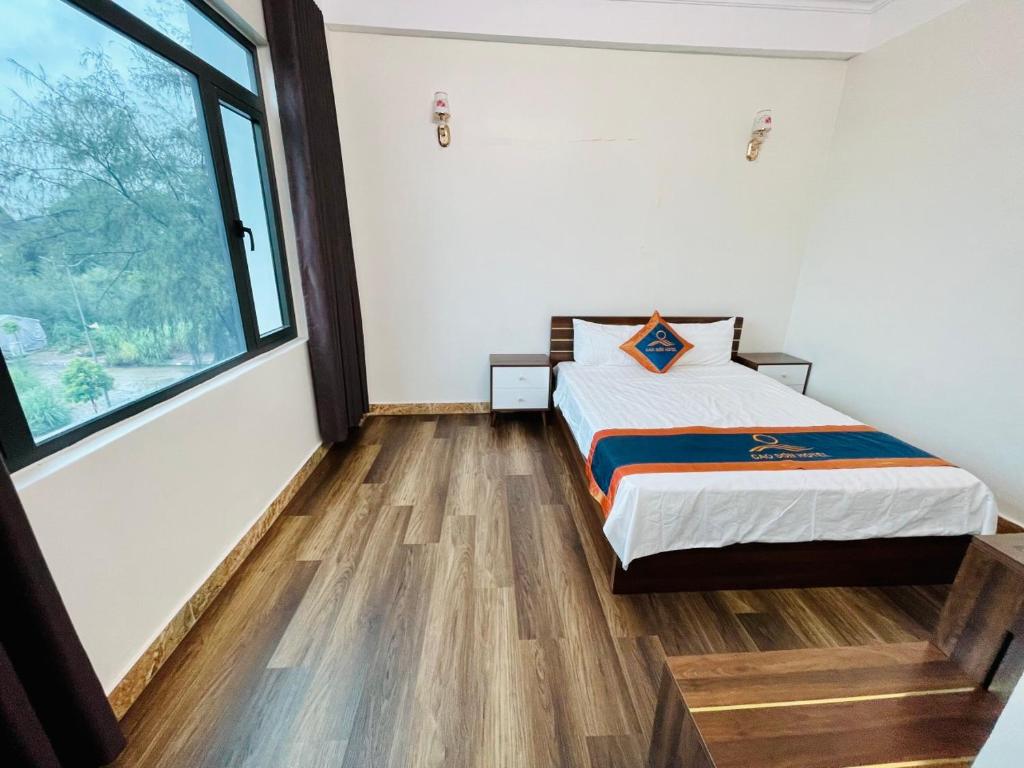 a bedroom with a bed and a large window at Khách sạn Cao Sơn in Cửa Ông
