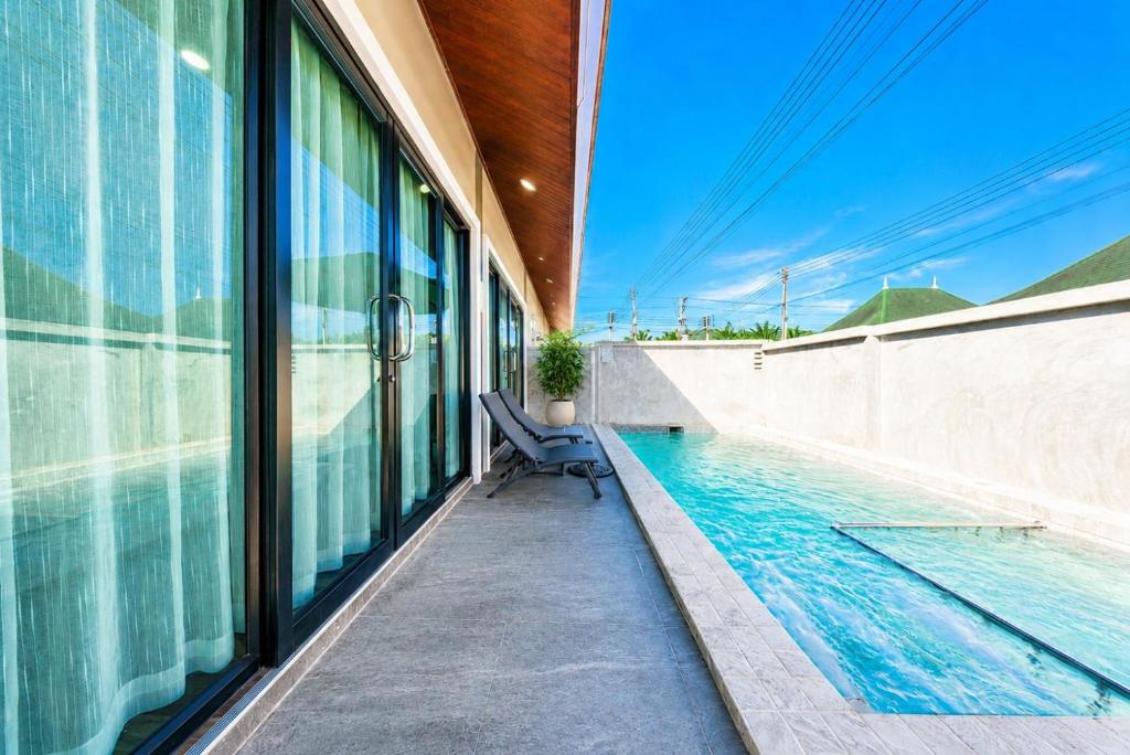 a swimming pool with a bench next to a building at Arterra Haven , Aonang Krabi in Ao Nang Beach