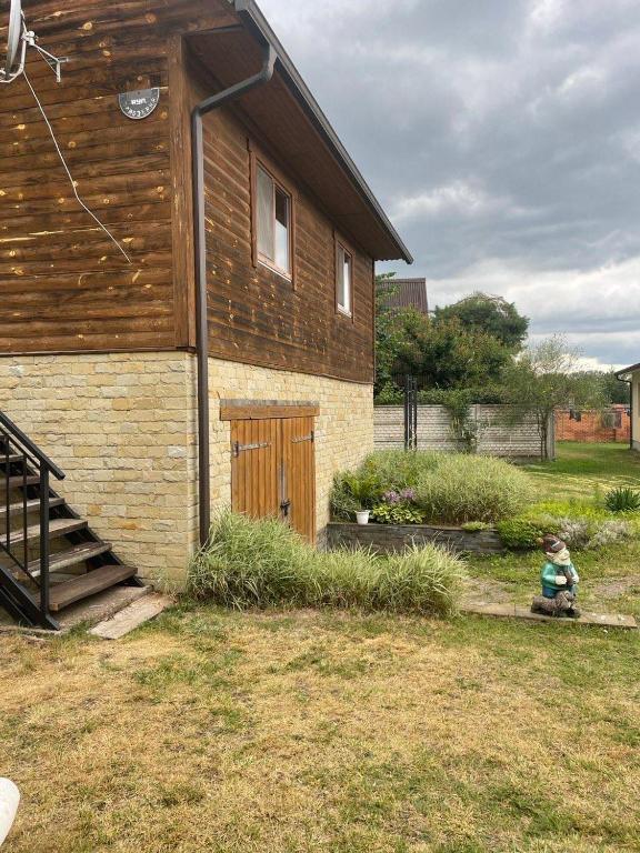 a young child sitting outside of a house at Затишок in Svityazʼ