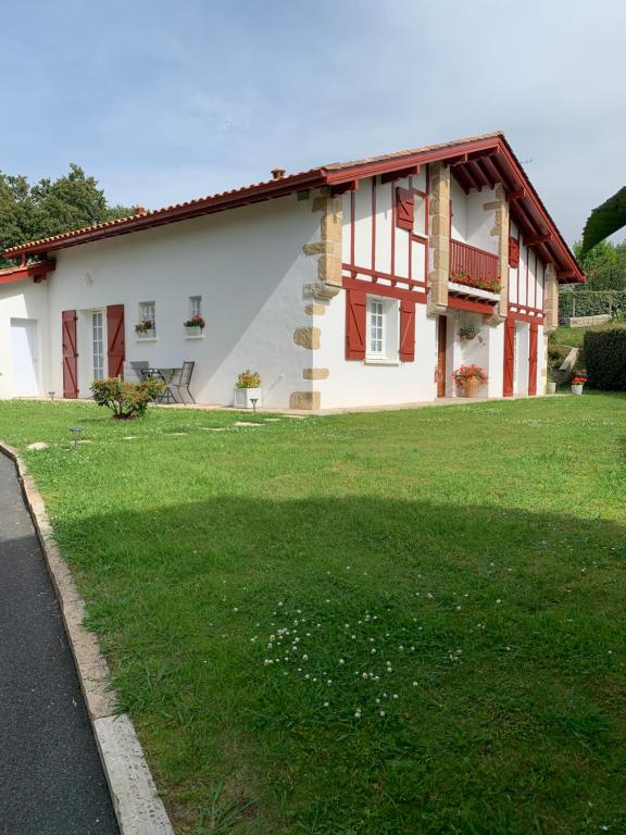 a house with a green lawn in front of it at Villa Les Hortensias B&B in Arcangues