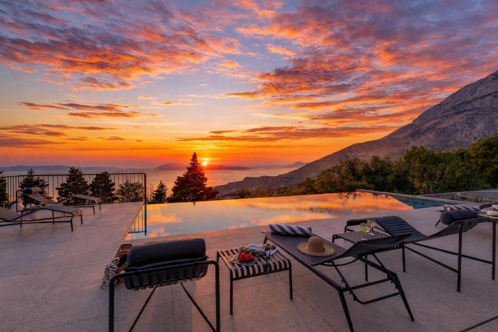 a view of a sunset from a patio with a pool at Villa Laurante in Tučepi