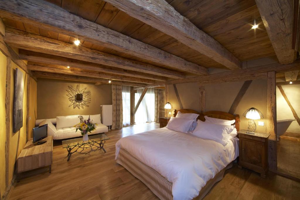 a bedroom with a large white bed and a couch at La Maison d'Artgile in Zimmersheim