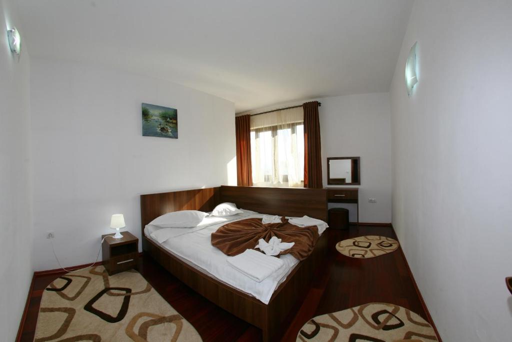 a bedroom with a bed with a wooden head board at Pensiunea Maria in Călimăneşti