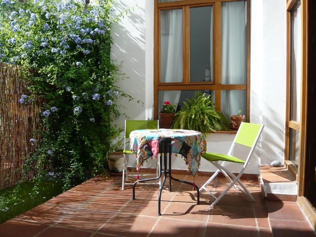 une table et des chaises assises sur une terrasse dans l'établissement Namaste, à Grazalema