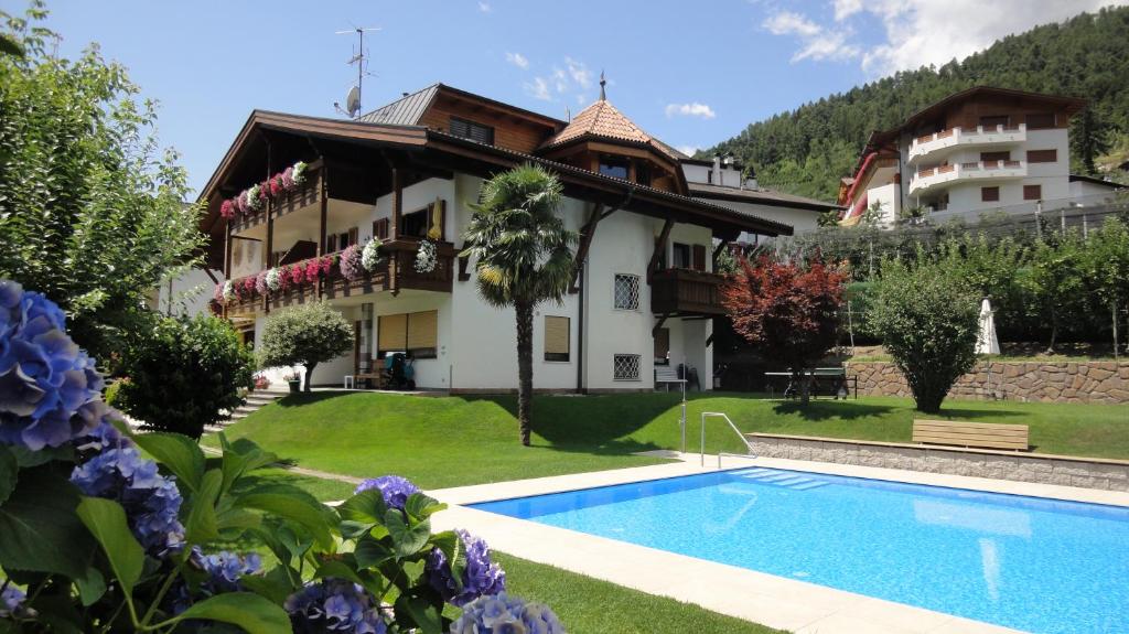 a villa with a swimming pool in front of a house at Ferienwohnungen Haus Christine in Rifiano