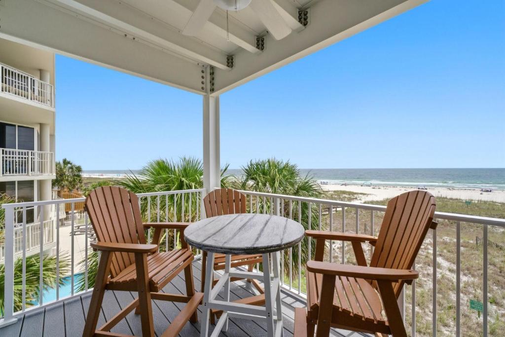 a balcony with two chairs and a table and the beach at Riviera Dunes 201 in Perdido Key