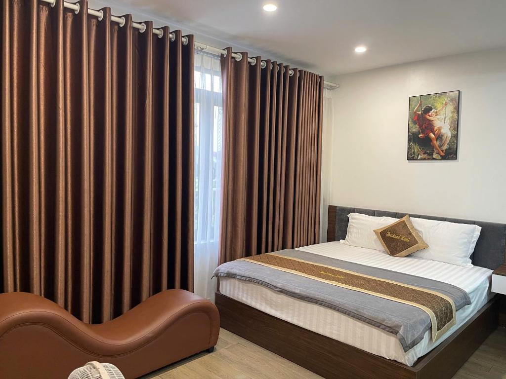 a bedroom with a bed and a window with curtains at Hotel Thái Lan in Hai Phong